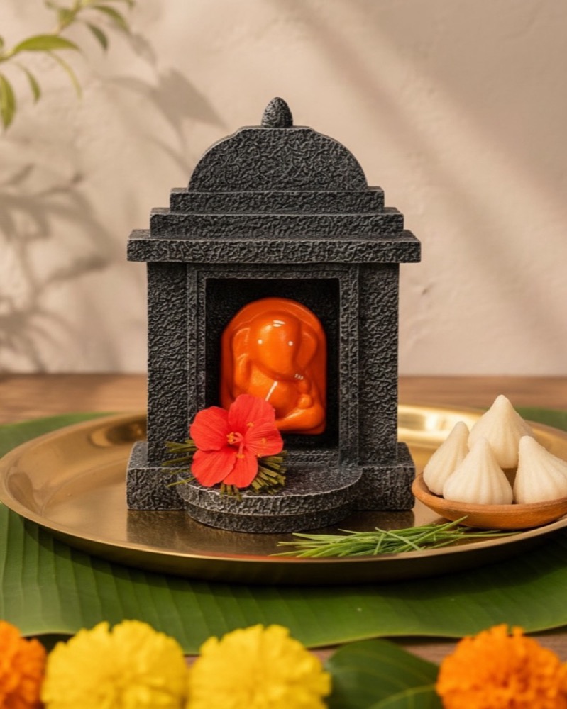 The shrine beside modak and durva on a brass thali.